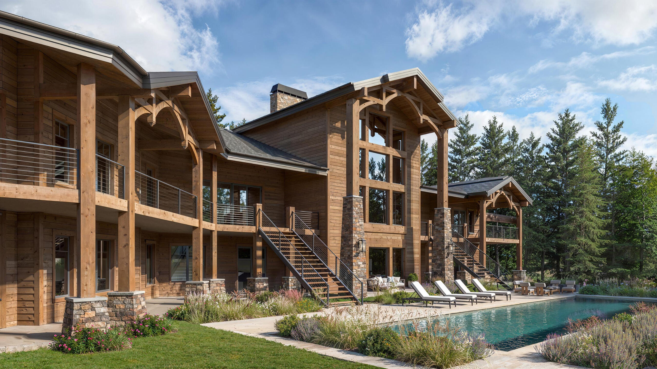 3D visualization of a luxury wooden mountain resort with pool and forest surroundings