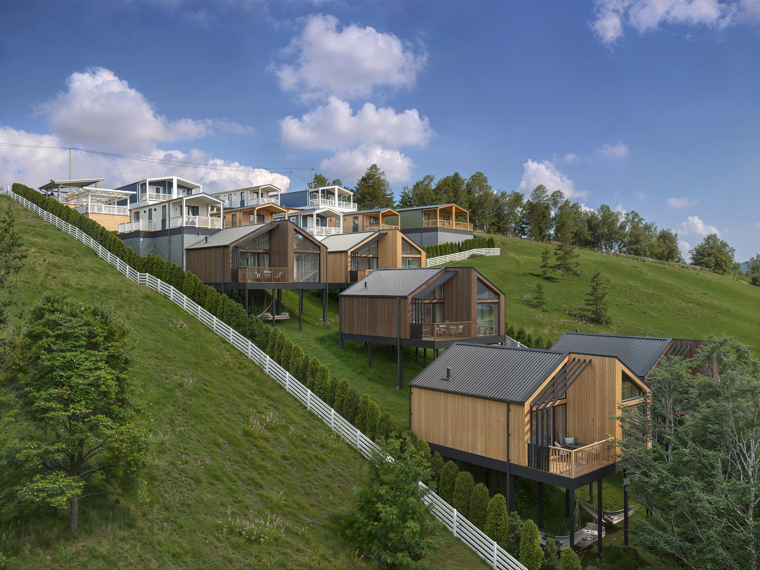 Mountain Eco-Lodges Render Photorealistic rendering of modern eco-lodges nestled on a hillside. High quality architectural visualization showcasing sustainable design and scenic mountain views.